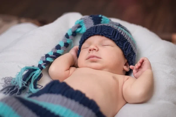 sleeping newborn dressed as a gnome baby on a white blanket sleeping newborn dressed as a gnome baby on a white blanket